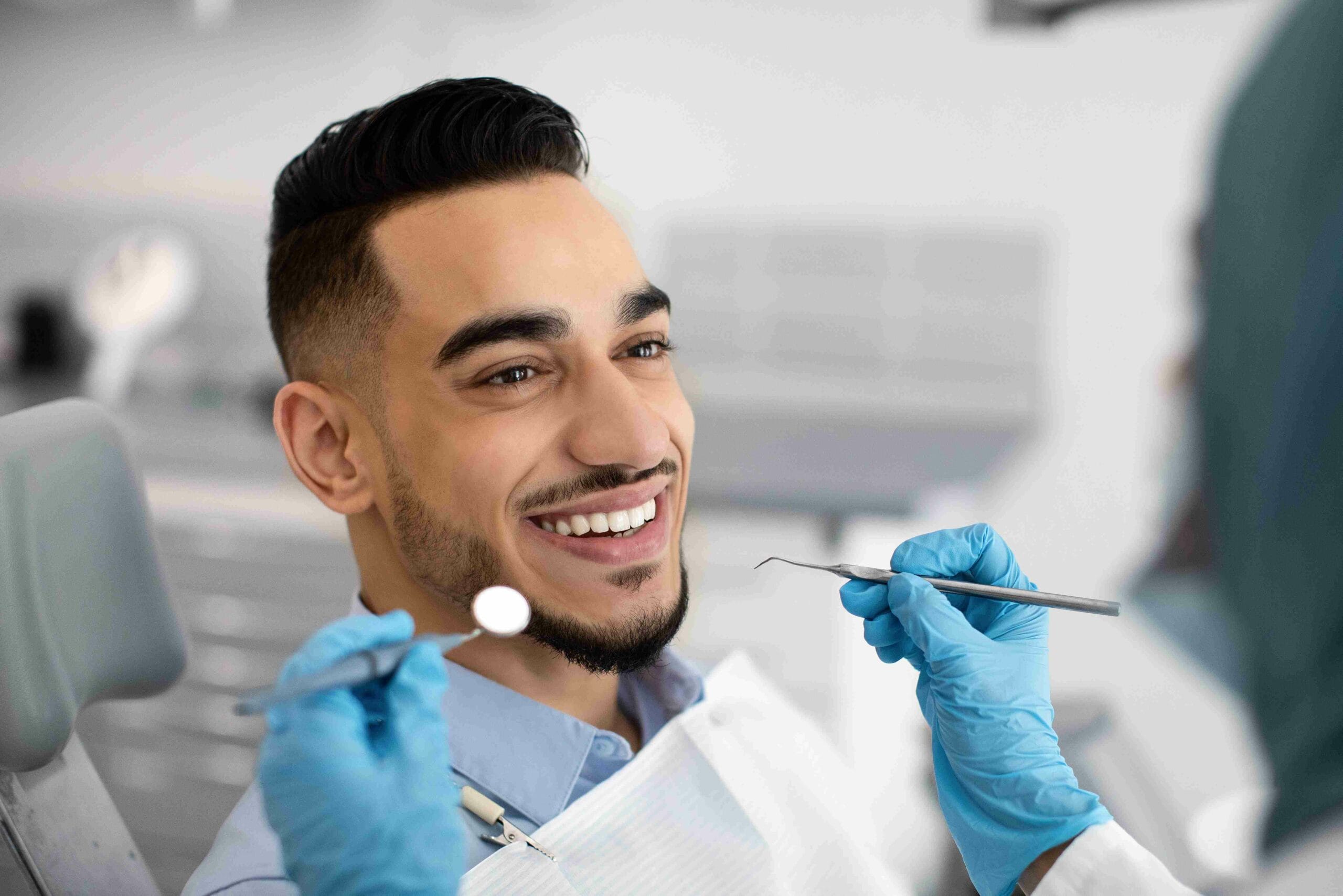 Happy Arab Man Sitting At Dentist Chair In Modern Clinic | TMZ Behavioral Care in Davie, FL