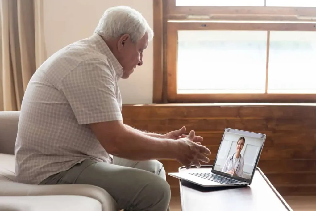 Senior man video chats with doctor online in telehealth service