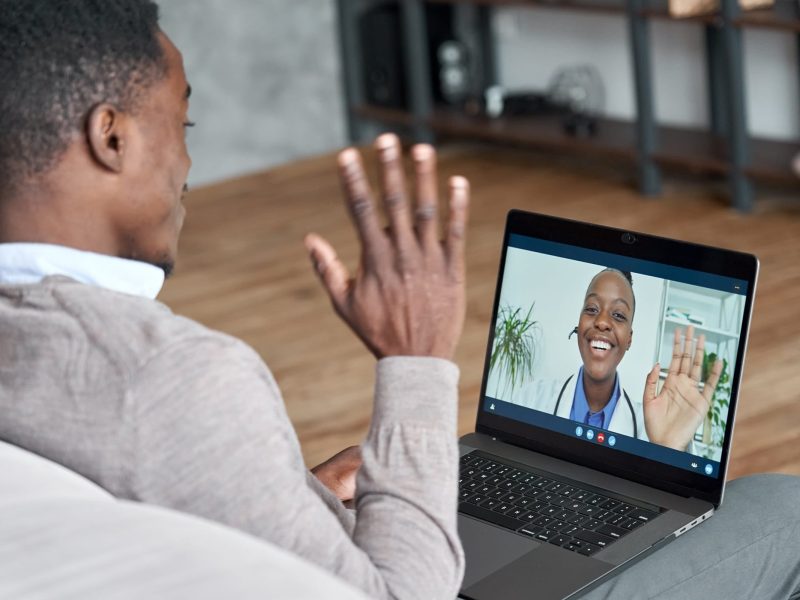 Male black patient talking on conference video call to female african doctor. Virtual therapist consulting young man during online appointment on laptop at home. Telemedicine chat, telehealth meeting | TMZ Behavioral Care in Davie, FL