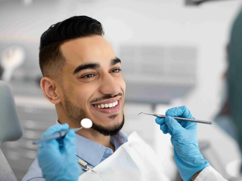 Happy Arab Man Sitting At Dentist Chair In Modern Clinic | TMZ Behavioral Care in Davie, FL